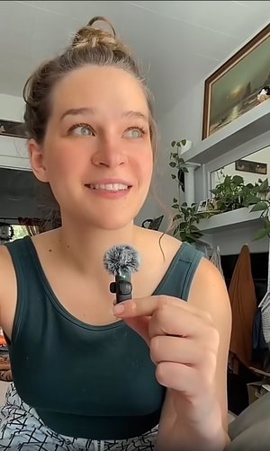 A creator holds up her Mini Mic Pro while filming