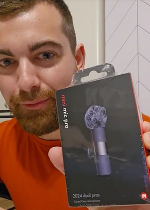 A creator holds the Mini Mic Pro box up to his camera
