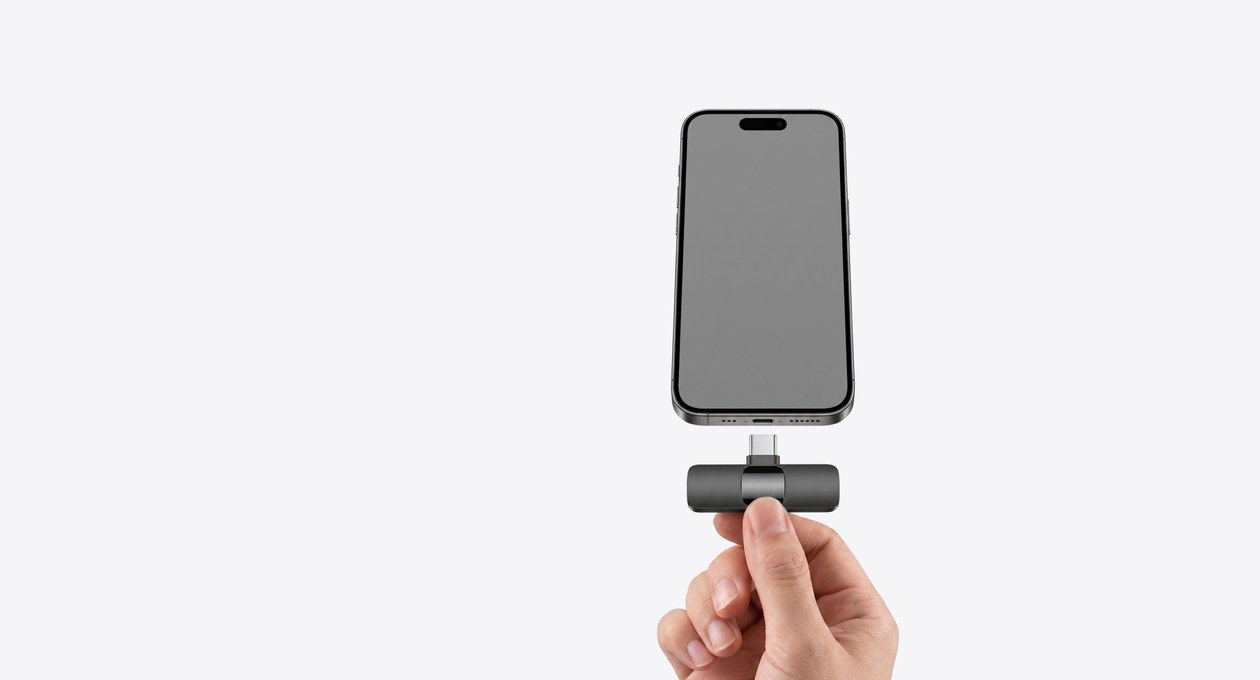A hand plugs the receiver into the bottom of a phone